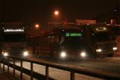 A Bus Passes Two Trucks In Heavy Snow
