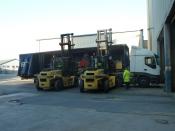 2 Forklifts Unloading A Machine.